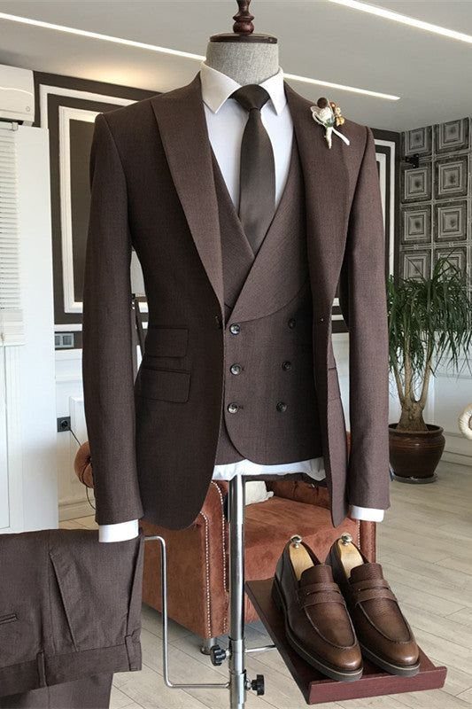A brown three-piece suit on a mannequin with matching loafers and trousers in a showroom.
