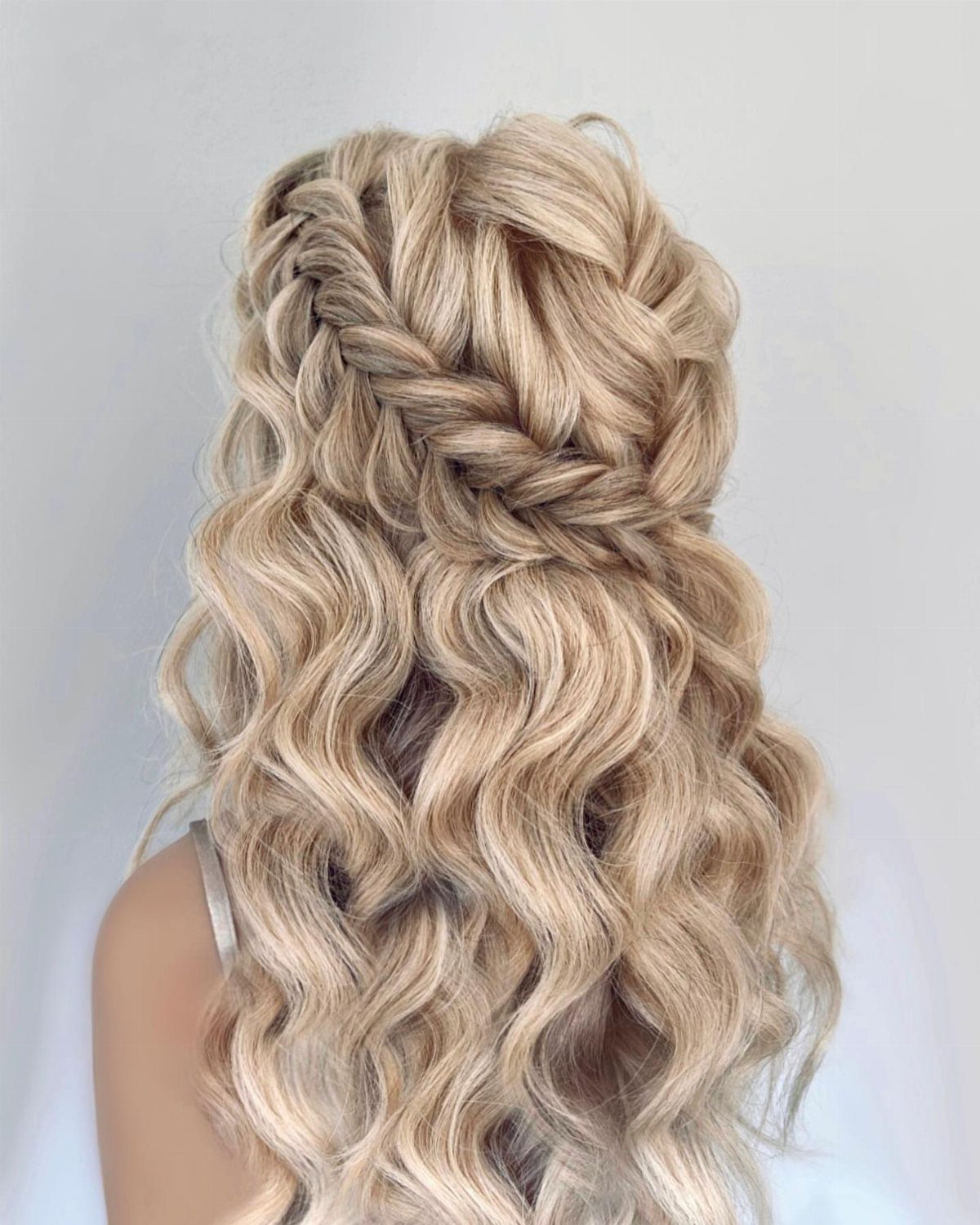 Long blonde hair styled with voluminous loose waves and thick textured braids.