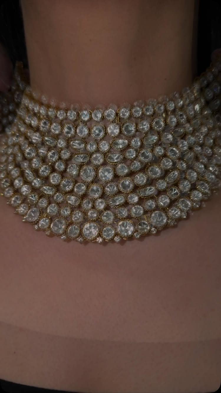 11 Bridal Diamond Necklace Ideas for Your Ceremony 8 A wide gold-toned choker necklace covered in many sparkling round diamonds worn around a neck.