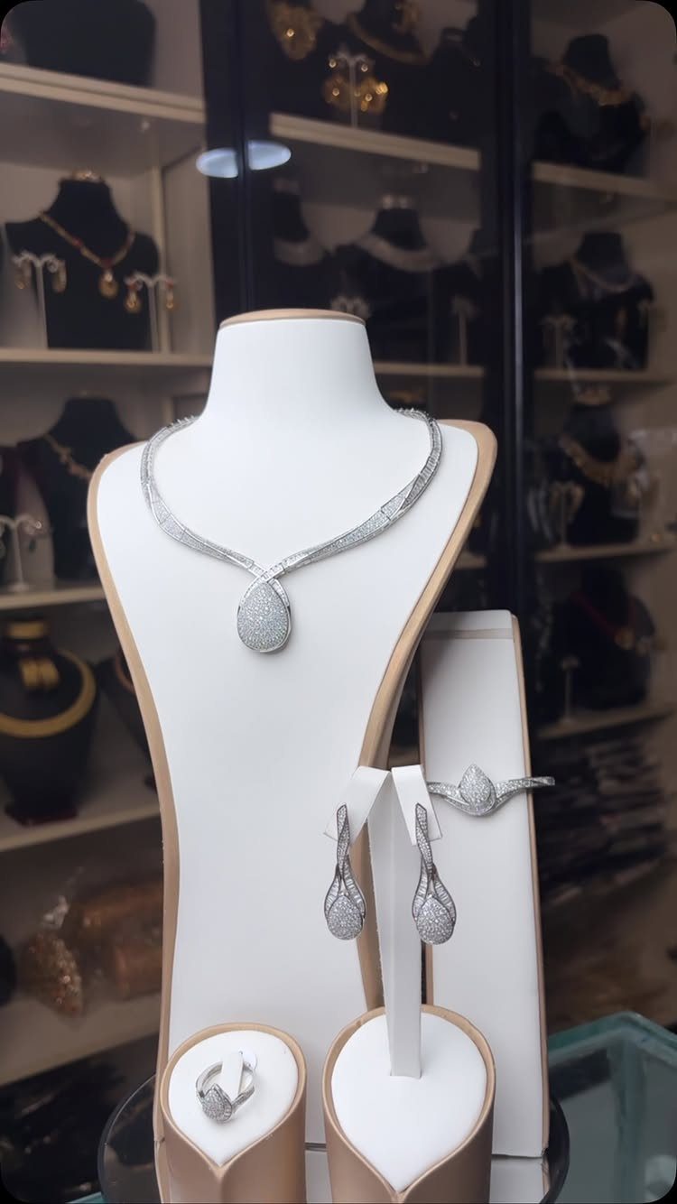 11 Bridal Diamond Necklace Ideas for Your Ceremony 2 Silver-toned diamond necklace with a large teardrop pendant displayed on a white jewelry bust.