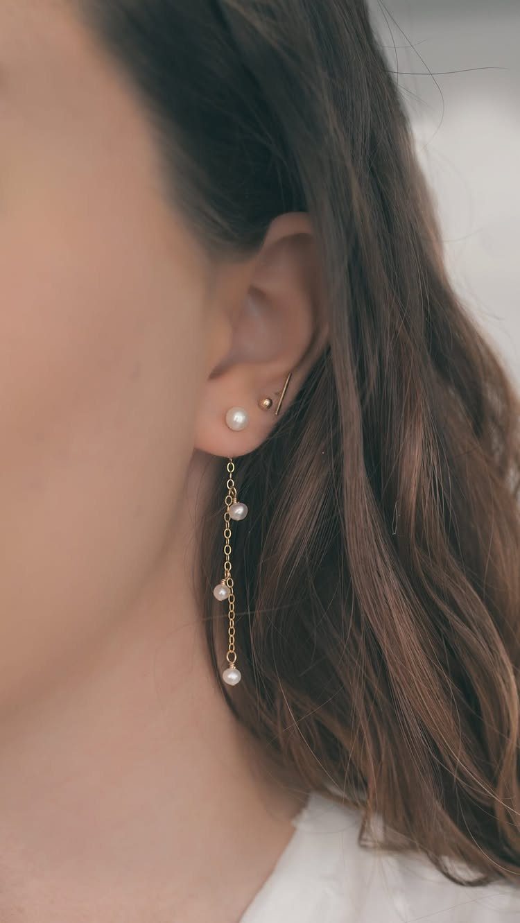 Bridesmaid Jewelry Gold: 10 Ideas for Every Wedding Style 7 A person's ear adorned with a pearl stud and long dangling pearl chain earrings.