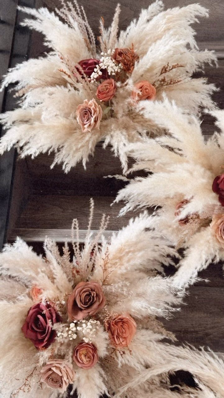 9 Earth Tone Wedding Colors That Feel Grounded, Not Dull 6 Dried floral arrangements with pampas grass and terracotta roses on a wooden surface.