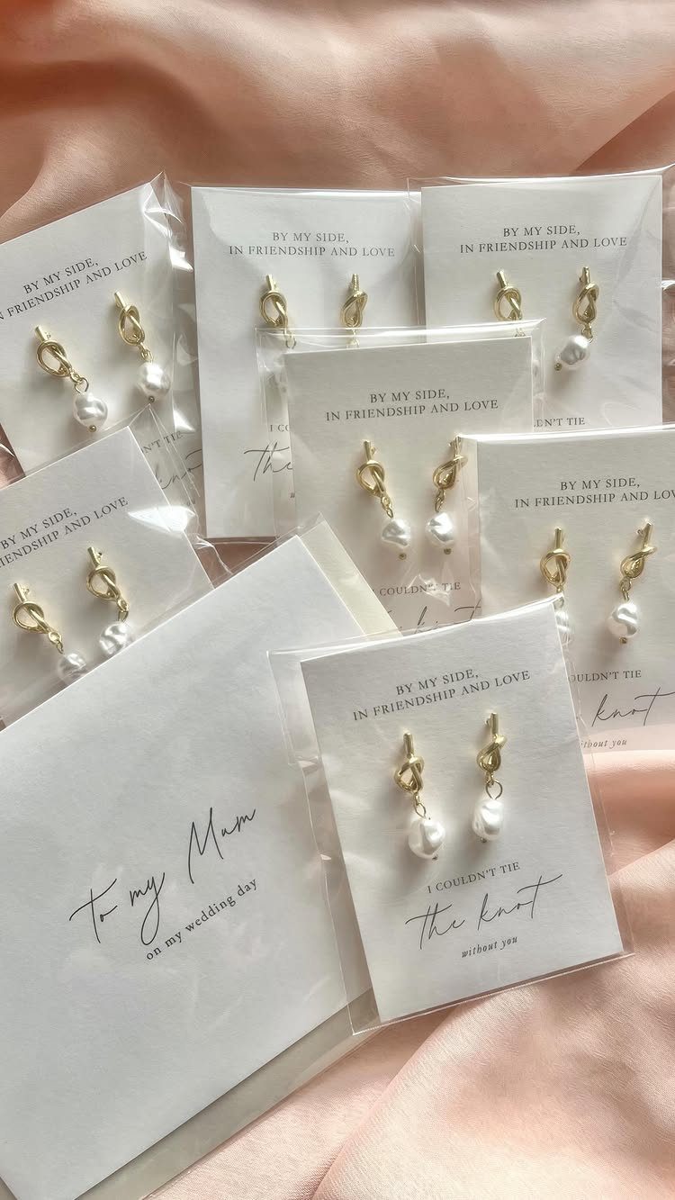 Multiple pairs of gold and pearl earrings packaged on cards with sentimental printed messages.