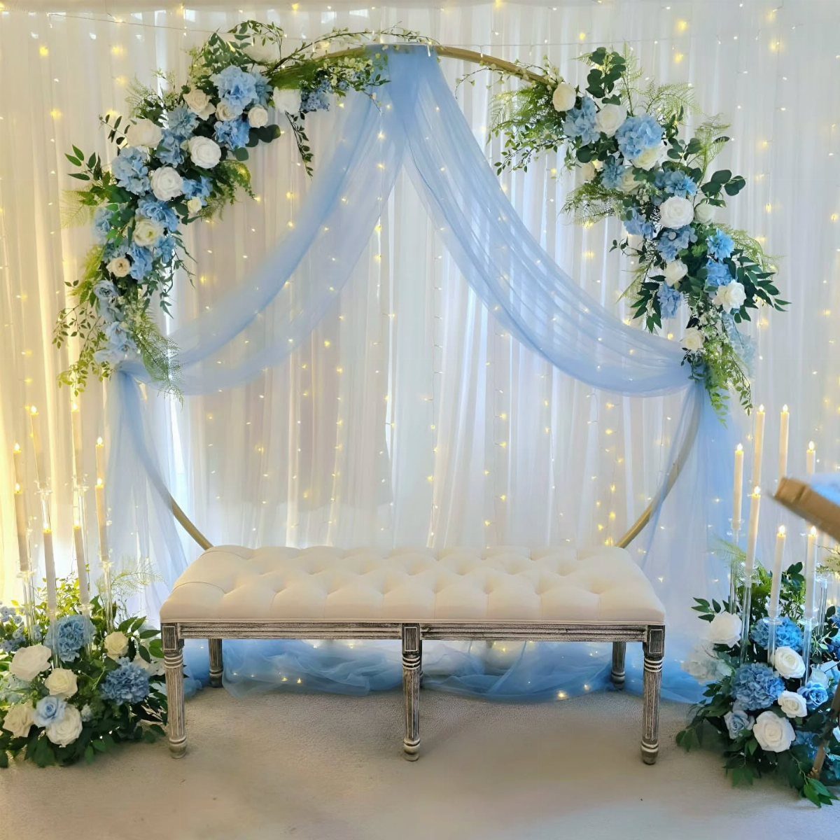 Light Blue Wedding: 8 Ideas From Cake to Tulle Runner 5 A gold circular wedding arch decorated with light blue and white floral arrangements and blue tulle.