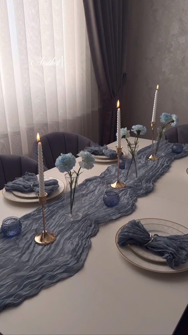 Light Blue Wedding: 8 Ideas From Cake to Tulle Runner 4 A dining table decorated with light blue textured runner, blue napkins, glassware, and white taper candles.