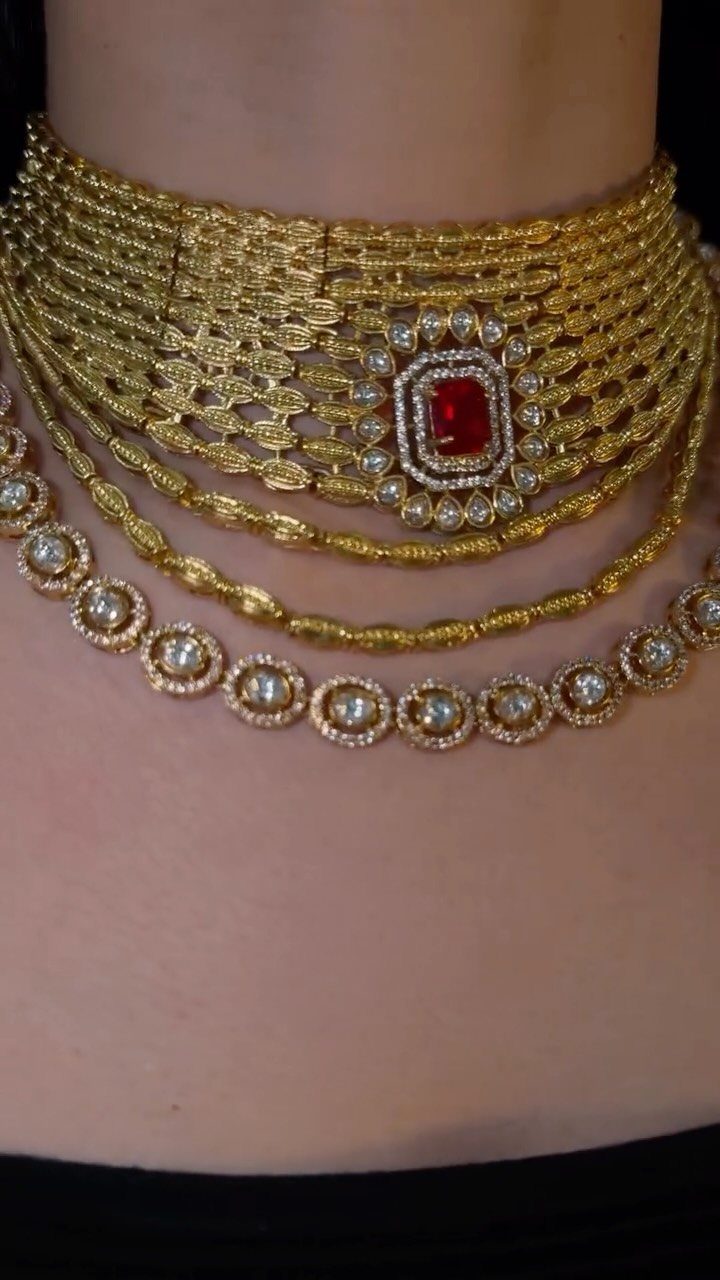 Gold choker necklace with a large central ruby and multiple layered stone strands.