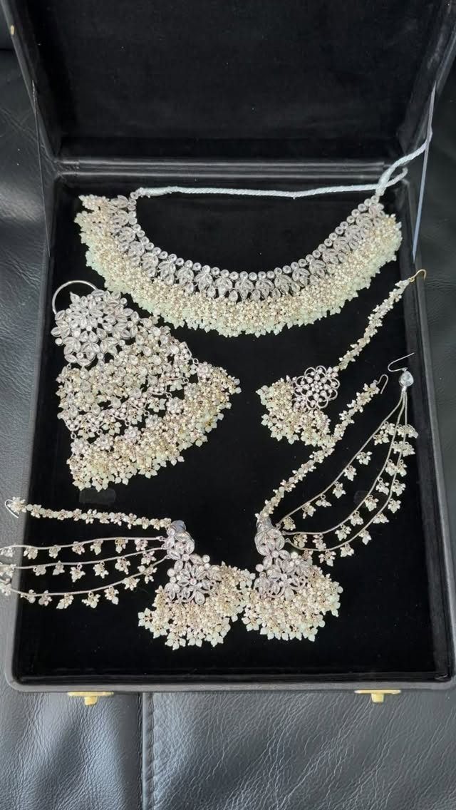 5 Silver Necklace Wedding Looks for Every Bridal Style 4 Intricate silver jewelry set with a necklace, earrings, and headpiece inside a black box.