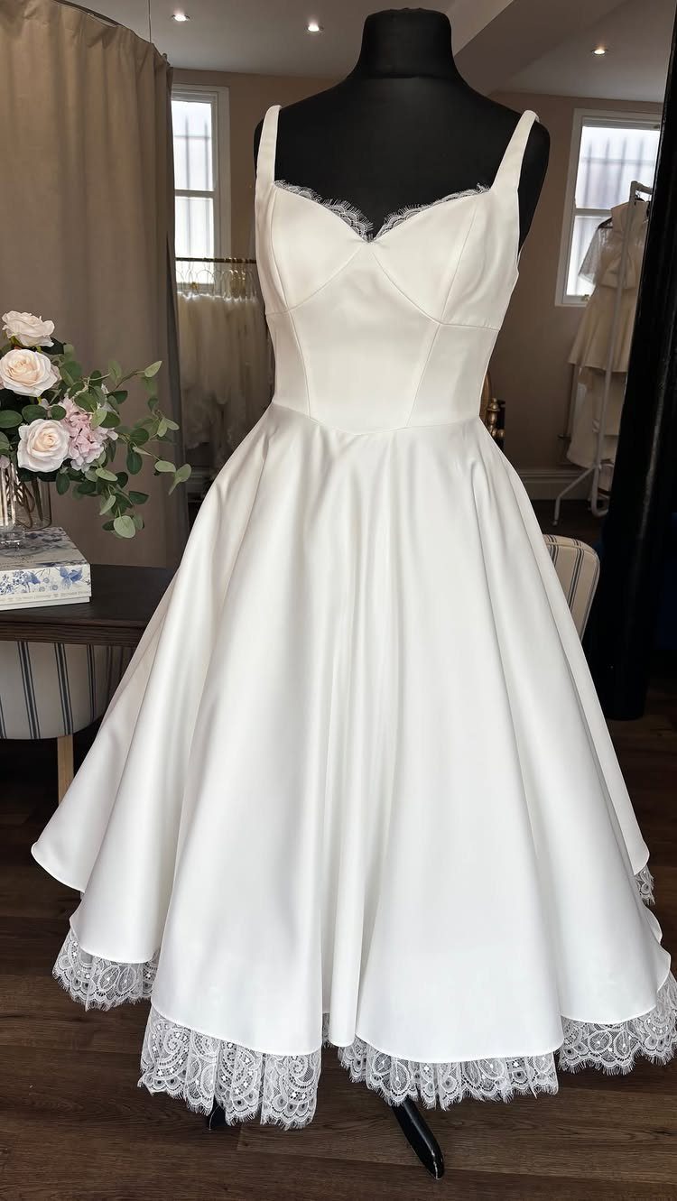 Simple Court Wedding Dress: 7 Styles That Work at City Hall 7 White satin midi dress with lace trim displayed on a black mannequin.