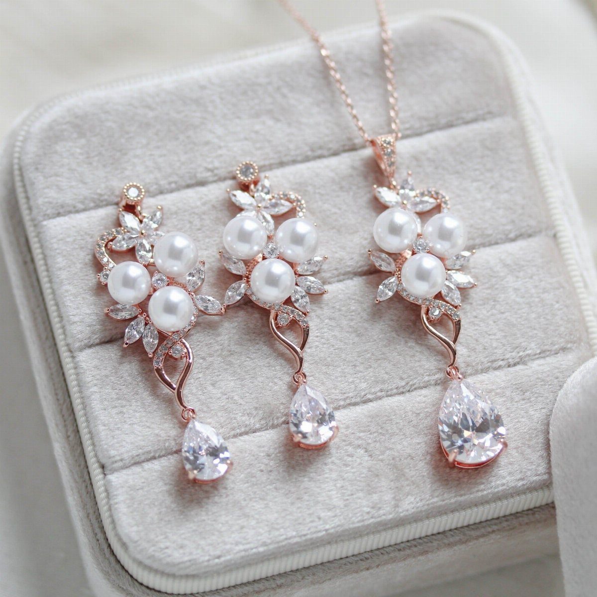 Rose gold pearl necklace and drop earrings with cubic zirconia in a velvet box.