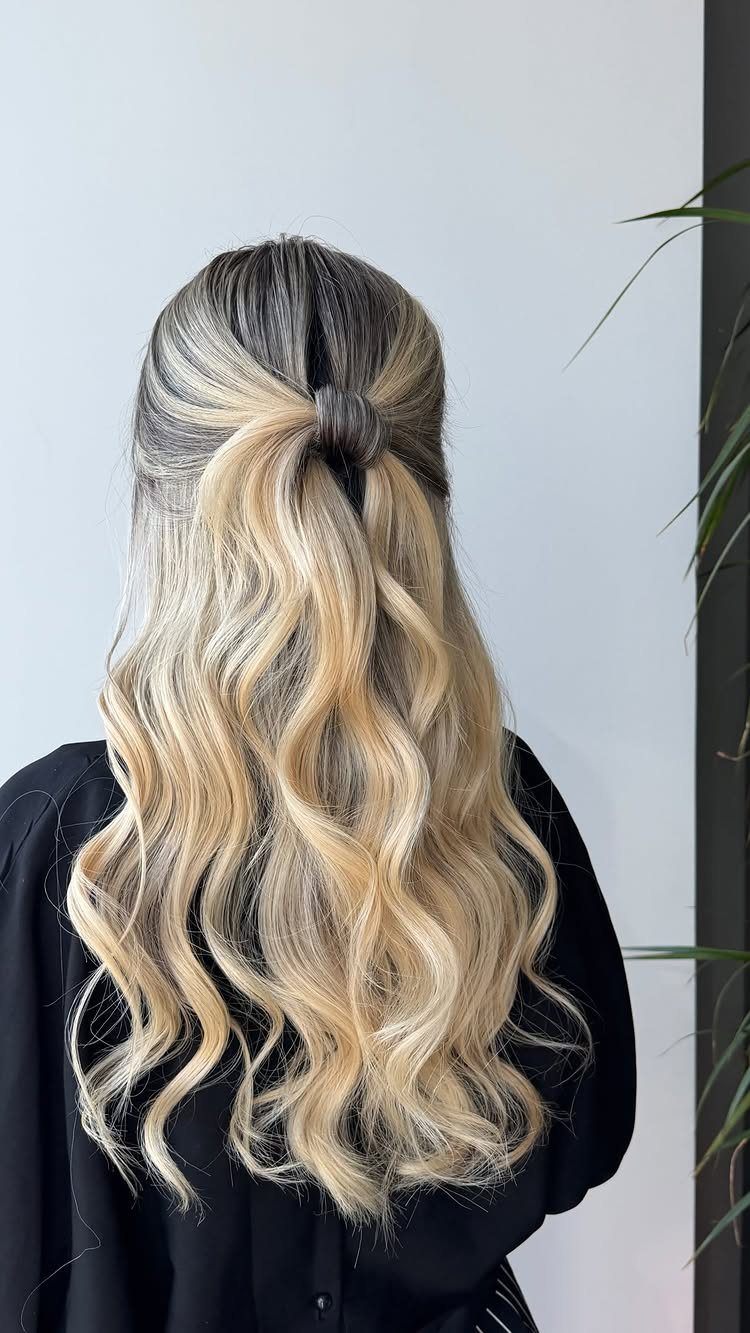 Long wavy blonde and brunette hair styled in a half-up relaxed knot.