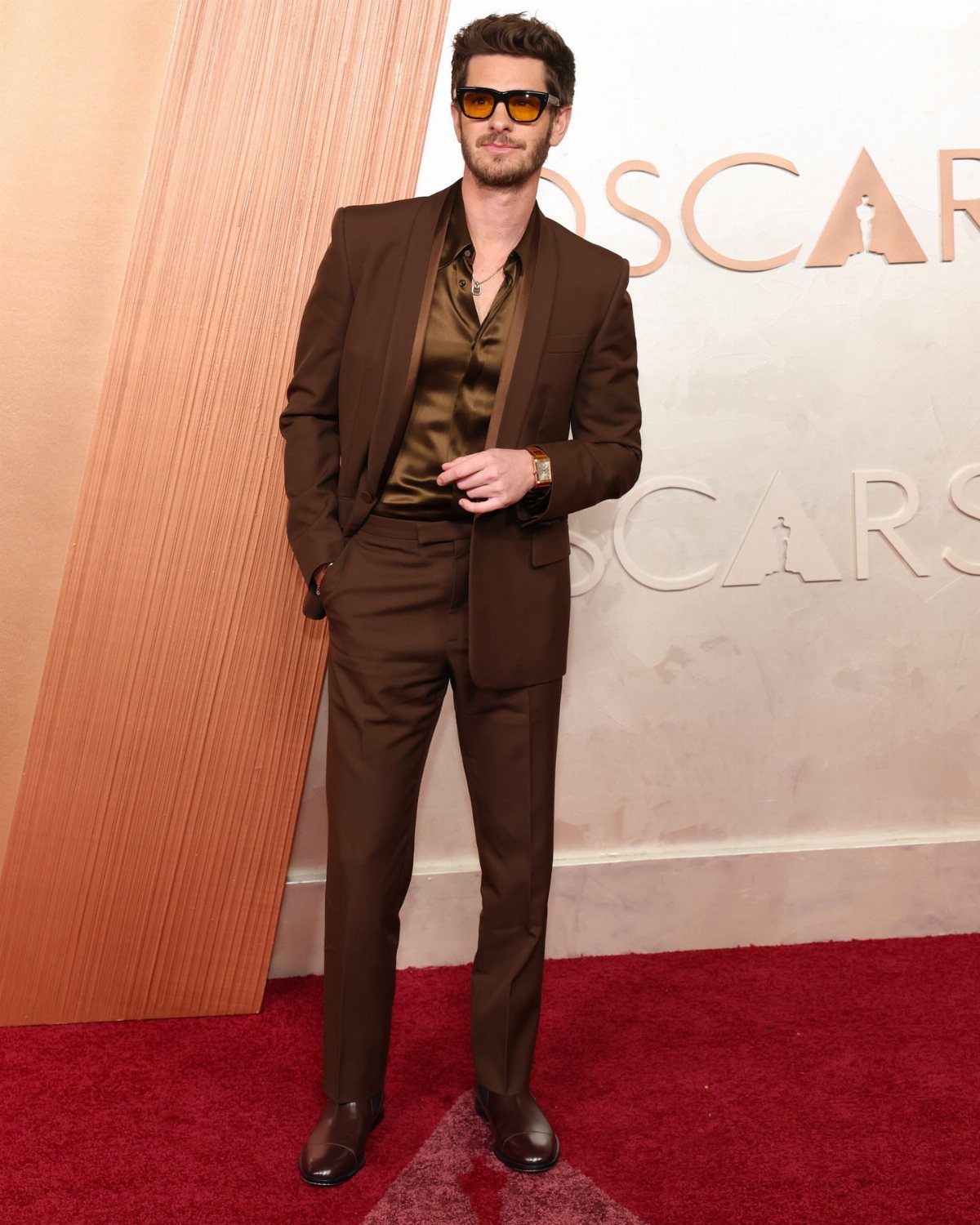 Wedding Suits for Men: 12 Groom Looks Outside Black Tie 1 A man in a brown suit and sunglasses posing on a red carpet.