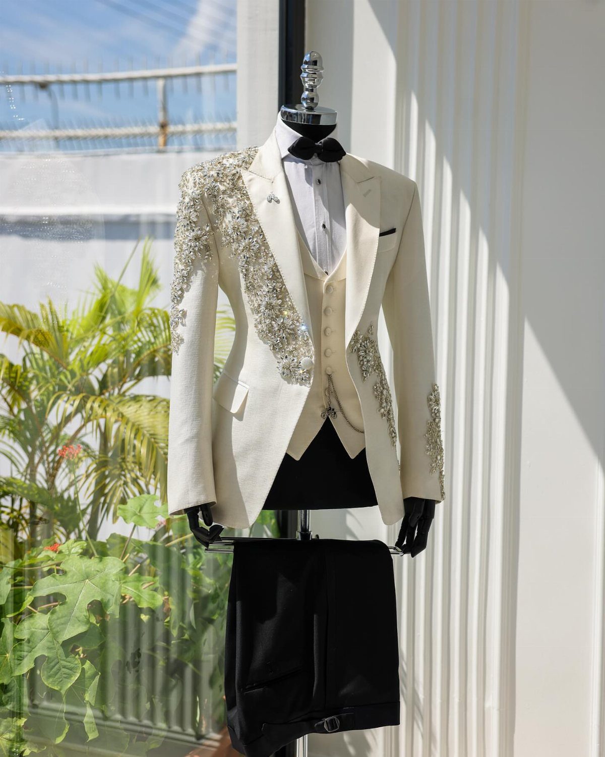 Wedding Suits for Men: 12 Groom Looks Outside Black Tie 9 Embellished cream tuxedo jacket with gold sequins displayed on a black mannequin.