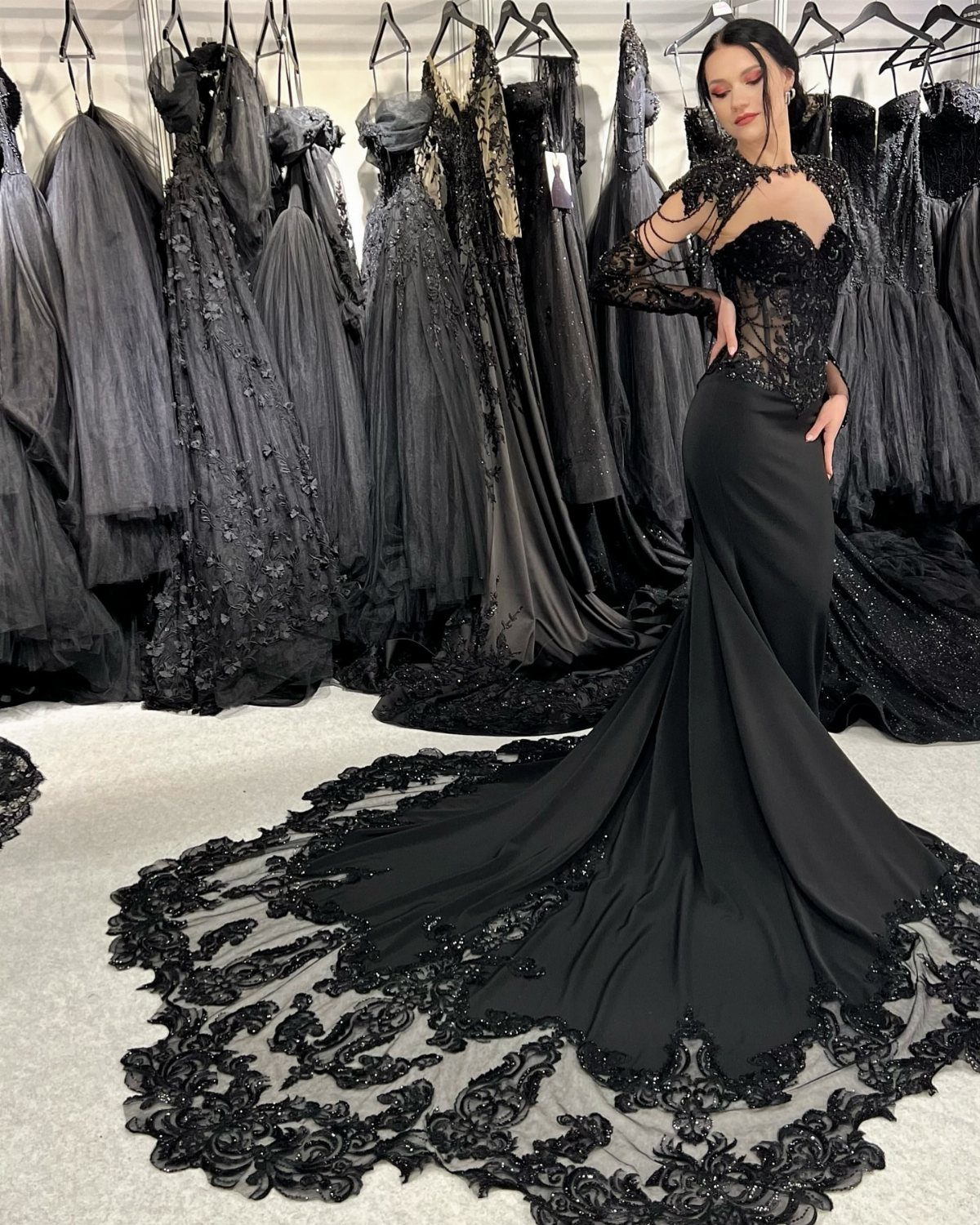 7 Enchanting Ideas for Witchy Wedding Dresses 1 A woman wearing a dramatic black lace mermaid wedding gown with a long embroidered train.
